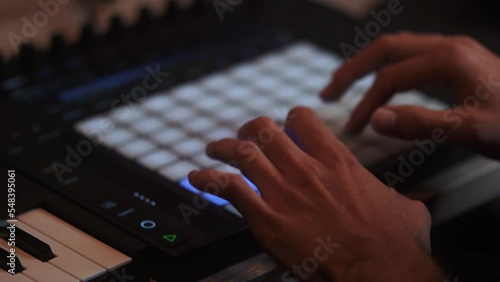 DJ is playing music on the AKAI MPK Music production hardware, Slow motion close up. Full HD photo
