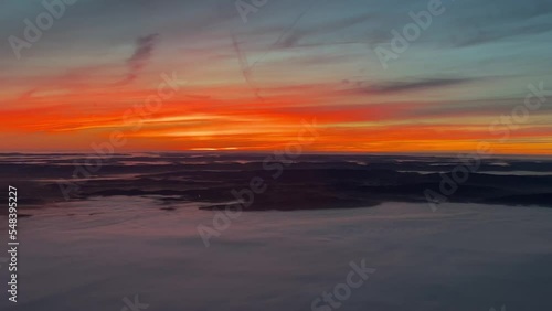 Exclusive aerial view from a jet cockpit flyigh southward over Germany at 8000m high at dawn with an intense red sky. photo