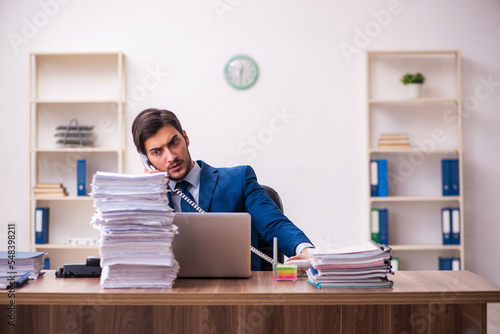 Young businessman employee unhappy with excessive work in the office