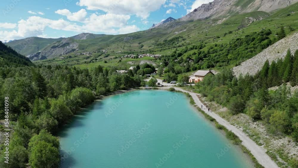 People hiking along turquoise light blue glacial lake in La Grave - La Meije, French Alps - Aerial Dolly Forward People hiking along turquoise light blue glacial lake in La Grave - La Meije, French Alps - Aerial Dolly Forward