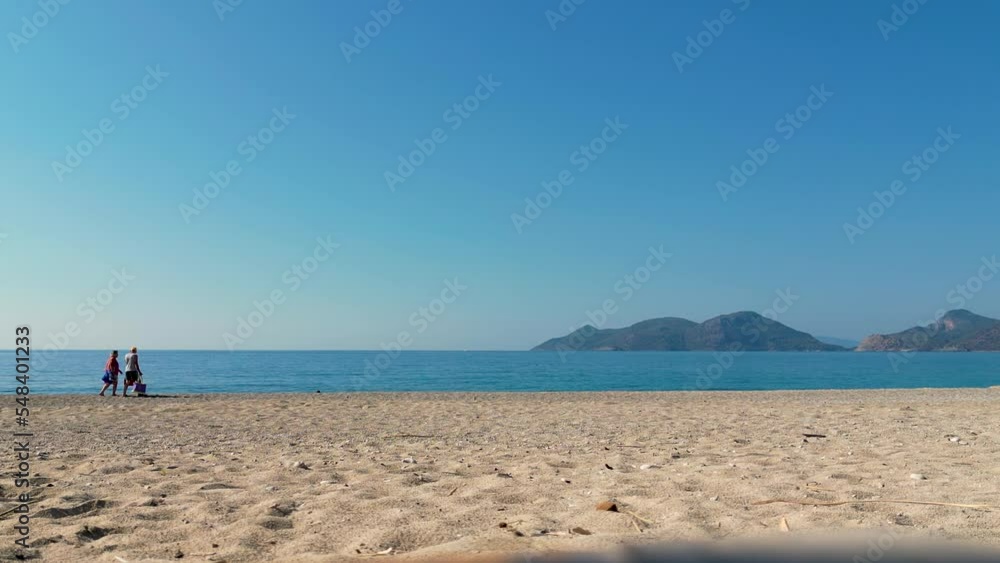 a couple on vacation walking along the beach - Ölüdeniz - Turkey a couple on vacation walking along the beach - Ölüdeniz - Turkey