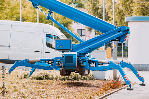 Industrial telescopic unmanned crane standing on hydraulic support legs like a spider at a construction site photo