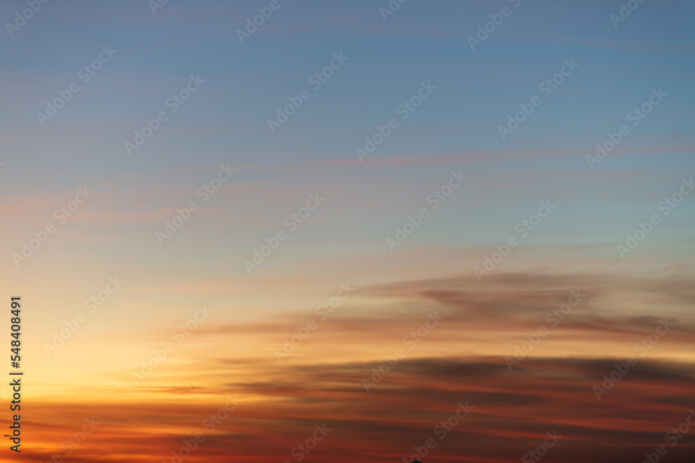 The dramatic colors of the sunset in the sky gradient from blue to orange. The dramatic colors of the sunset in the sky gradient from blue to orange.