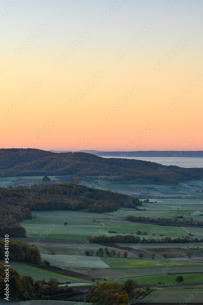Panorama-Ausblick vom Aussichtsturm auf der Berggipfel Zabelstein bei Hundelshausen im Steigerwald, Blick über das Maintal nach Schweinfurt und Gerolzhofen bei Sonnenaufgang und Nebelschwaden