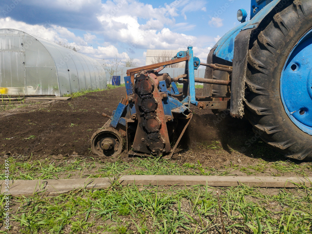 Obraz premium The tractor plows the soil on the field