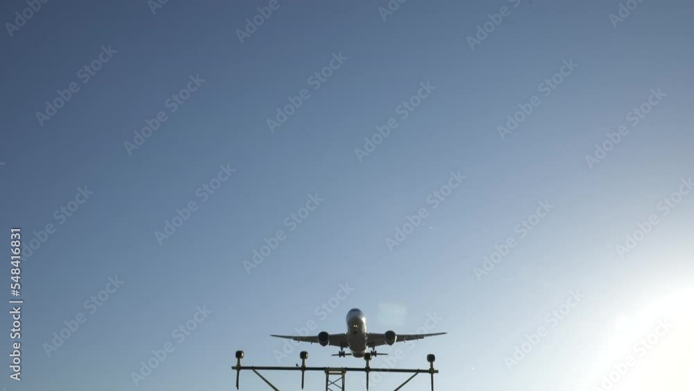 Slow motion commercial passenger jet flies overhead on final approach Slow motion commercial passenger jet flies overhead on final approach