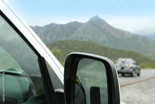 Beautiful view of car on asphalt highway in mountains, closeup. Road trip