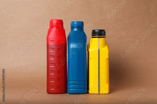 Motor oil in different canisters on light brown background