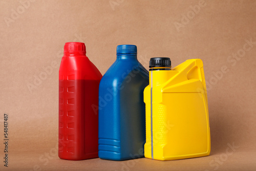 Motor oil in different canisters on light brown background