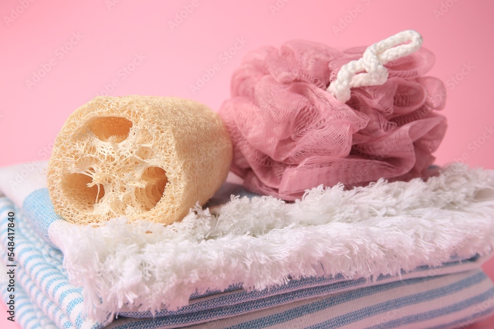Shower puff, loofah sponge and towel on pink background, closeup Shower puff, loofah sponge and towel on pink background, closeup
