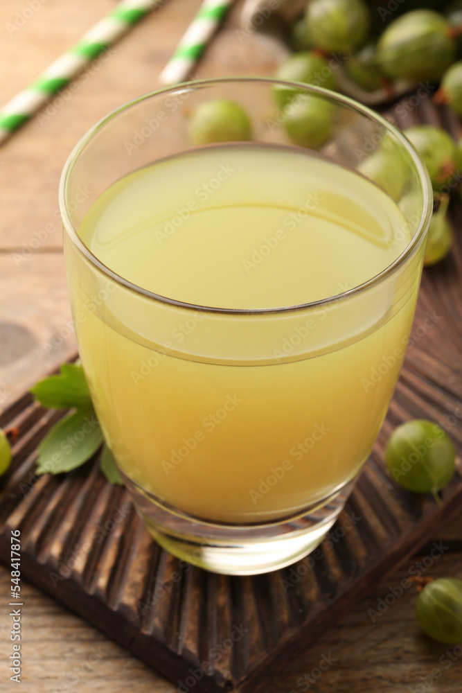 Tasty gooseberry juice and fresh berries on wooden table, closeup Tasty gooseberry juice and fresh berries on wooden table, closeup