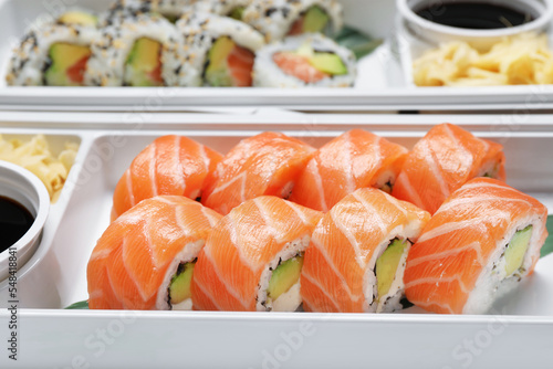 Delicious sushi rolls in plastic containers, closeup. Food delivery