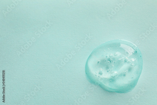 Sample of face gel on light blue background, top view. Space for text