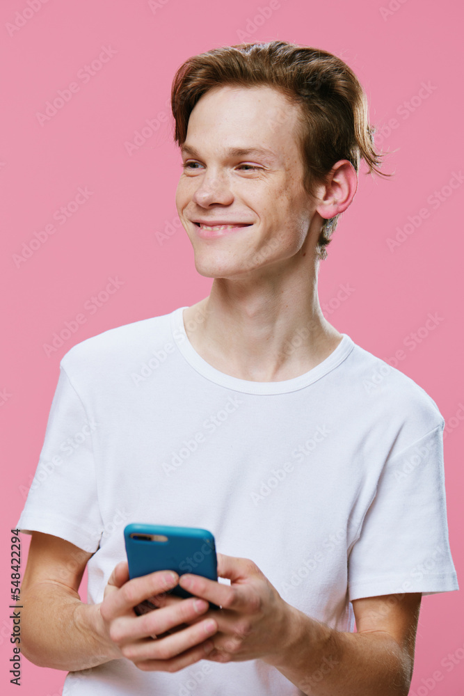cute nice guy with a thoughtful smile typing a text message on the phone cute nice guy with a thoughtful smile typing a text message on the phone