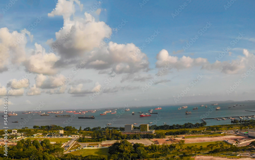 Panoramic view from drone of Marina Bay and Singapore skyline on a sunny afternoon.