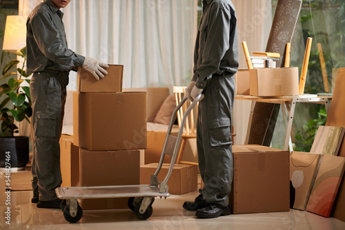 Movers Putting Boxes on Boving Cart photo