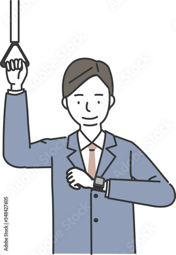 つり革につかまりスマートウォッチをチェックするビジネスマン
