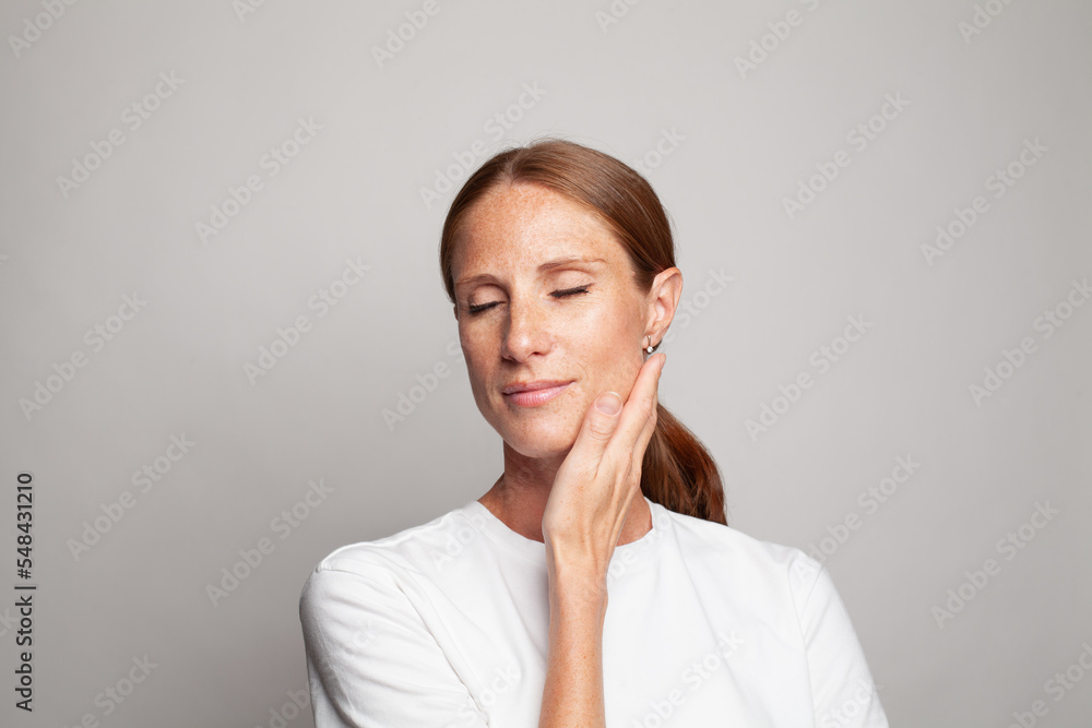 Nice relaxing mature woman with clean healthy skin and closed eyes on white background Nice relaxing mature woman with clean healthy skin and closed eyes on white background