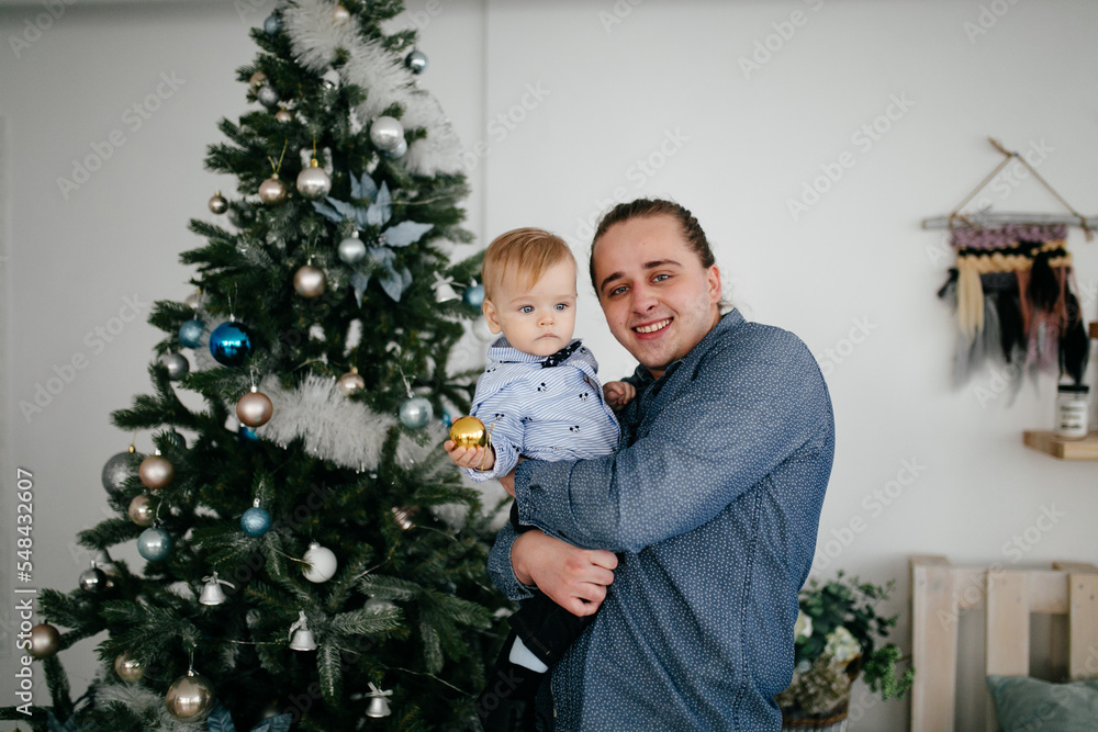 Happy smiling family at studio on background of the Christmas tree with gift Happy smiling family at studio on background of the Christmas tree with gift