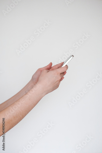 two hands of a freelancer on the side holding a white phone on a white background
