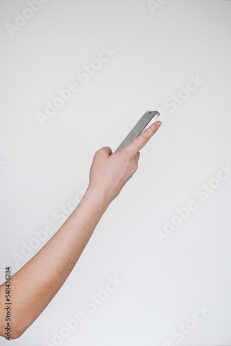 right hand of a freelancer on the side holding a white phone on a white background