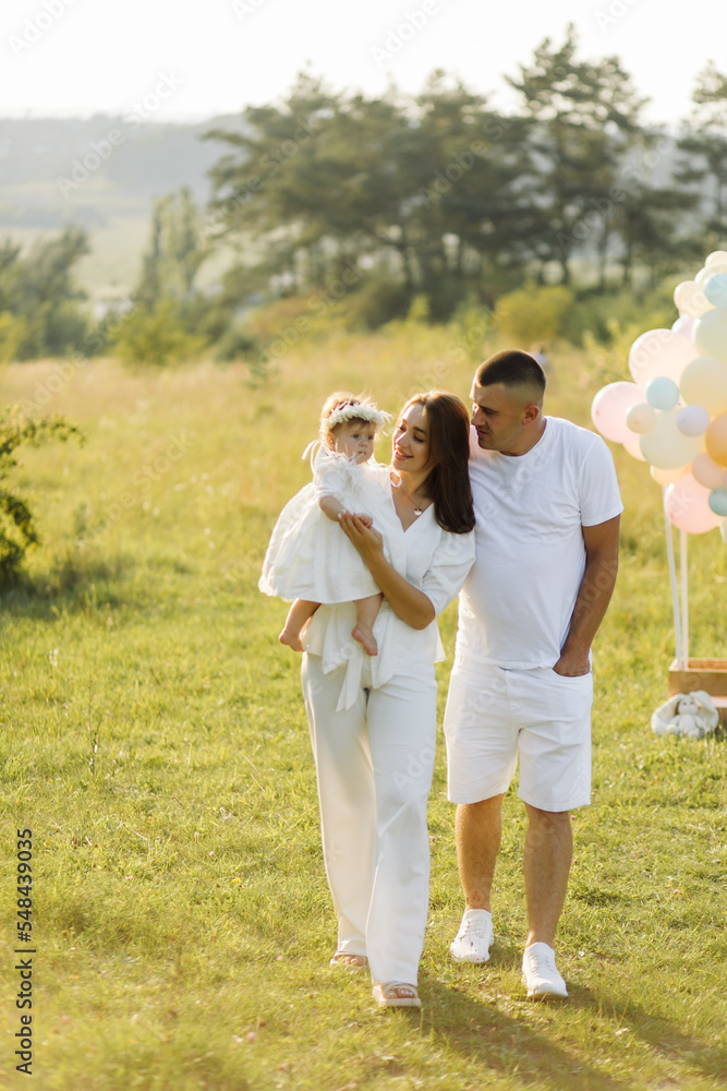 Young family with cute little daughter walking in forest on the sunset Young family with cute little daughter walking in forest on the sunset