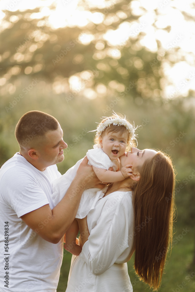 Young family with cute little daughter walking in forest on the sunset Young family with cute little daughter walking in forest on the sunset