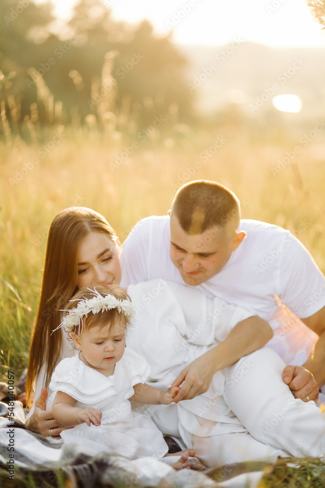Young family with cute little daughter walking in forest on the sunset Young family with cute little daughter walking in forest on the sunset