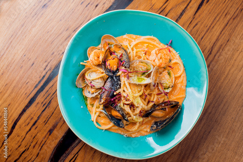 pasta with mussels in tomato sauce on a blue plate