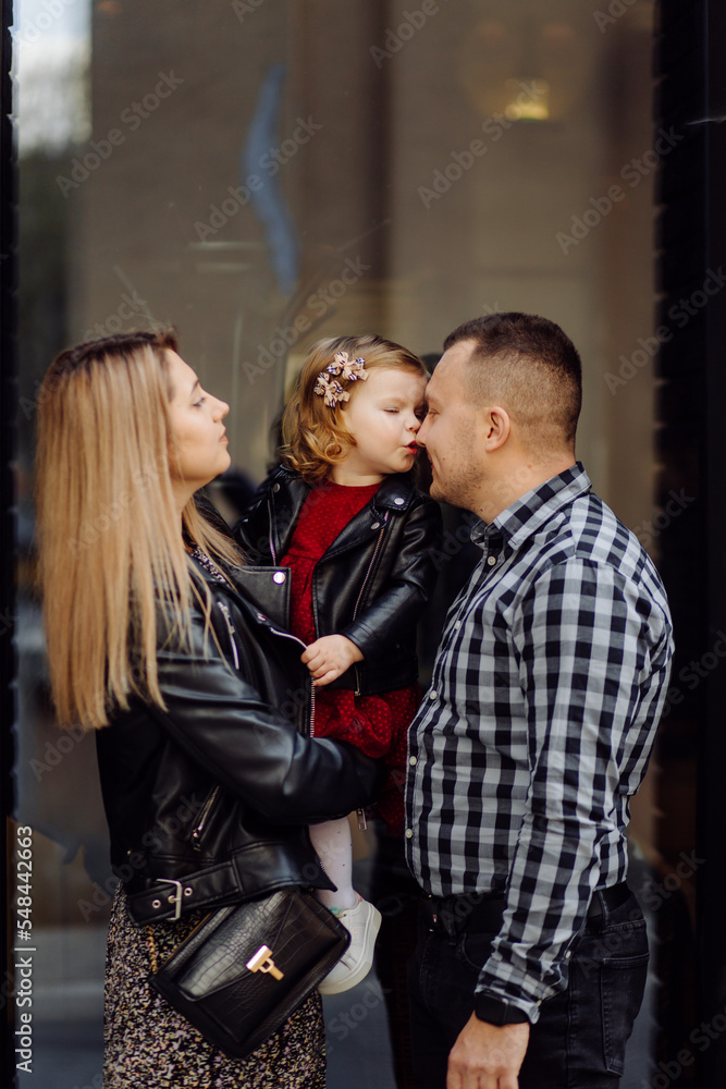 Parents and daughhter walking around the city. Spend time together. They are happy Parents and daughhter walking around the city. Spend time together. They are happy