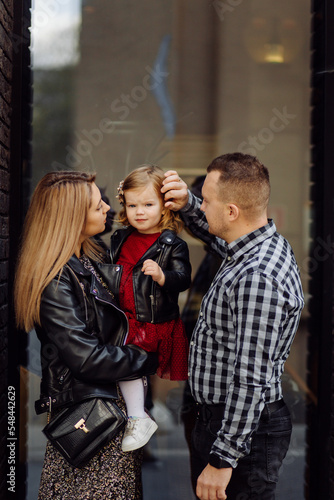 Parents and daughhter walking around the city. Spend time together. They are happy © andriyyavor