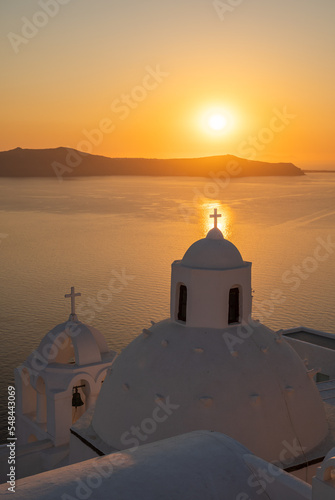 Santorini, white church against colorful sunset in Greece