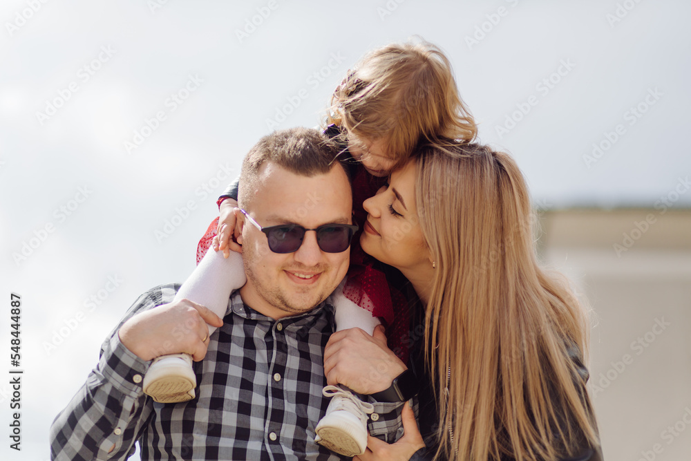 Parents and daughhter walking around the city. Spend time together. They are happy Parents and daughhter walking around the city. Spend time together. They are happy