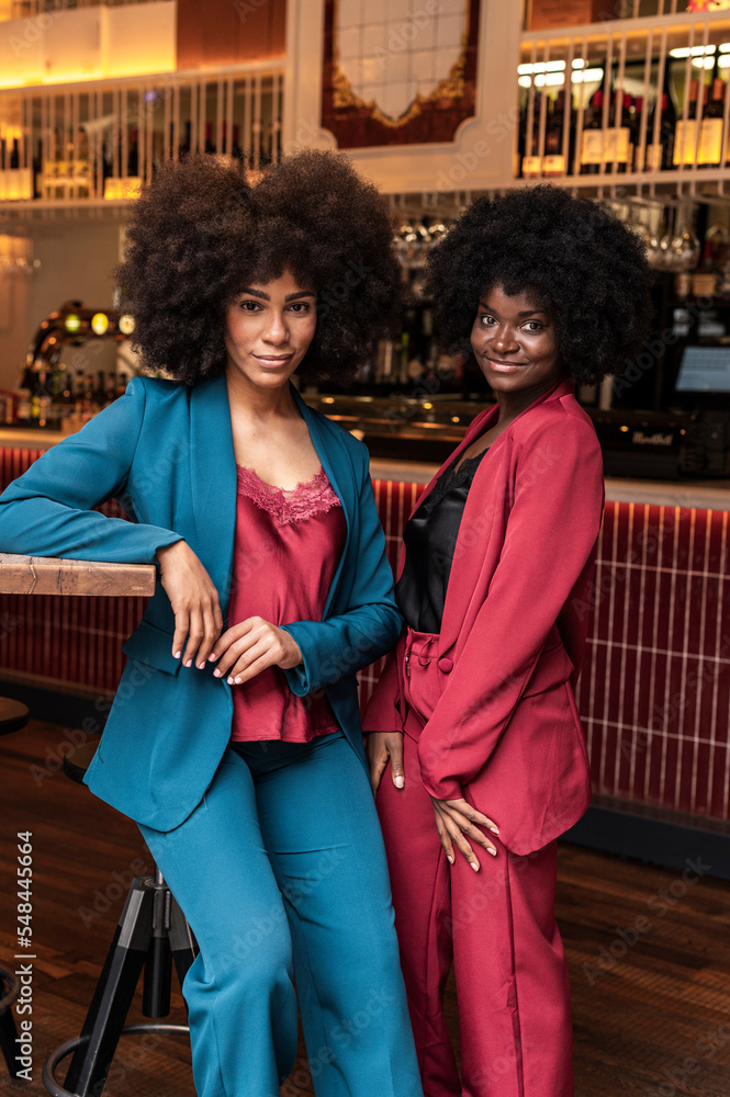 Multiracial women with afro at restaurant Multiracial women with afro at restaurant