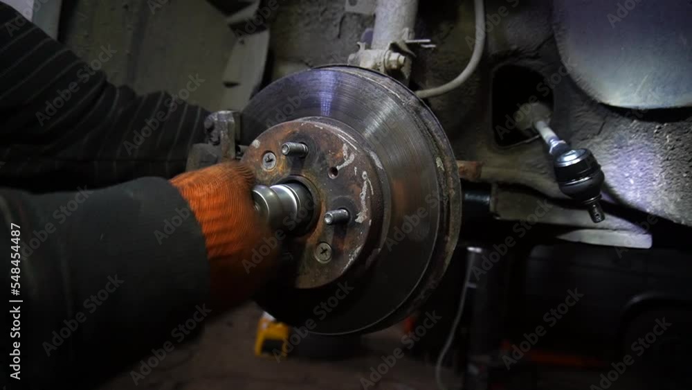 a mechanic disassembles an old dirty car engine on a red lift for repair and tuning a mechanic disassembles an old dirty car engine on a red lift for repair and tuning