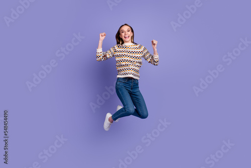 Full body photo of lovely girl raising hands up win arms jumping screaming isolated over bright background