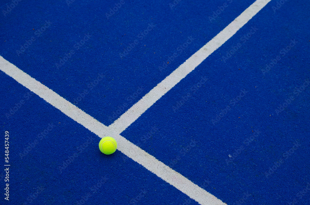 ball close to the line on a blue paddle tennis court