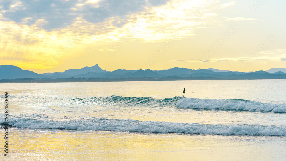 people doing surf in Byron bay, Australia at sunset