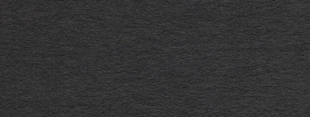 Texture of old dark black color paper background, macro. Structure of a vintage craft cardboard.