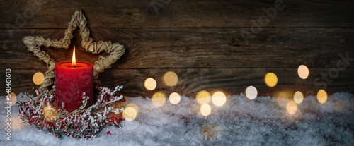 Photographie Christmas candle in winter snow landscape with magic lights