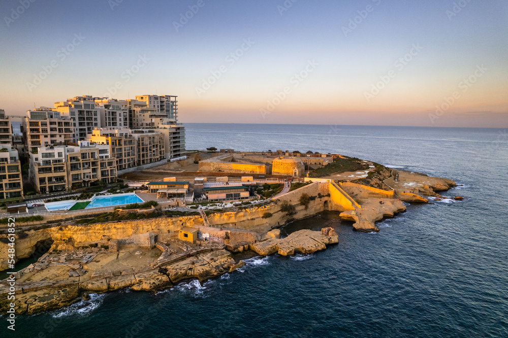 Sliema seaside resort in Malta at sunset, blue ocean waters, aerial drone view
