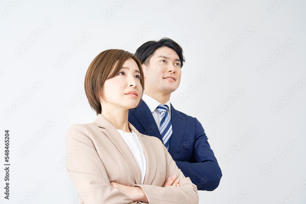 腕組みするビジネスウーマンとビジネスマンのポートレート　