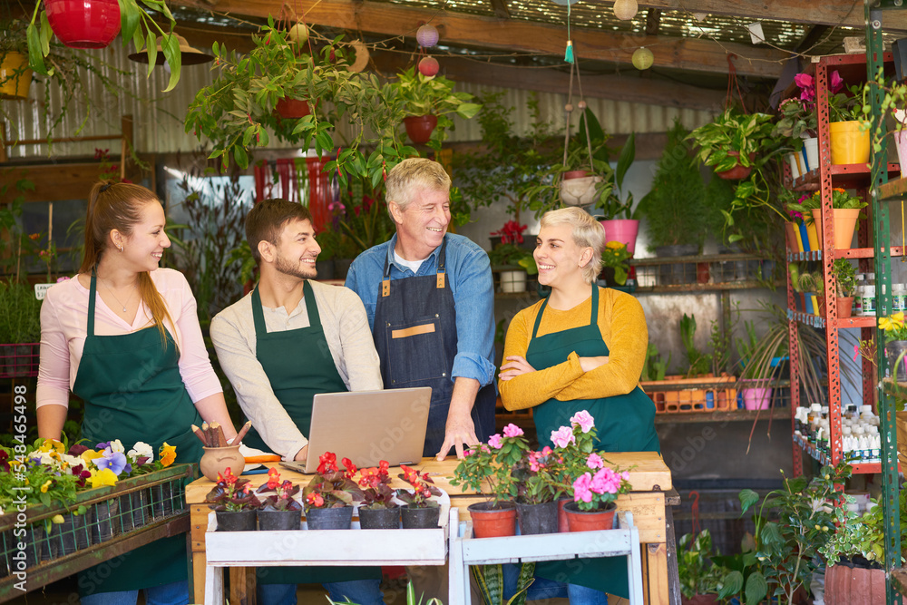 Obraz premium Satisfied gardeners team in the flower shop of the nursery