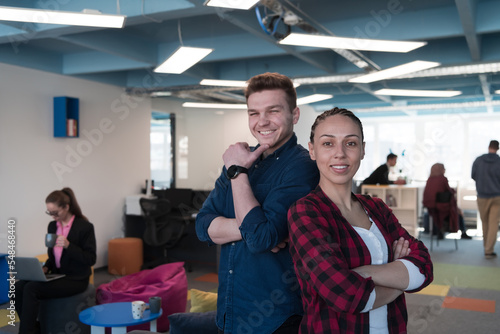 Portrait of a successful creative businessman and businesswoman looking at camera and smiling. Diverse business people standing together at startup.
