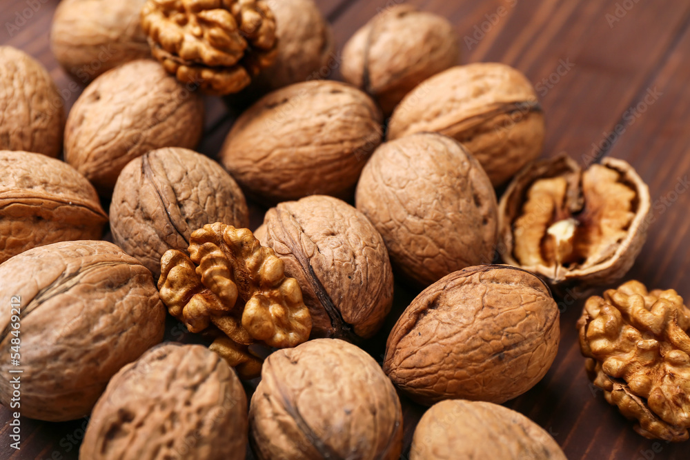 Whole and peeled walnuts on wooden background, closeup Whole and peeled walnuts on wooden background, closeup