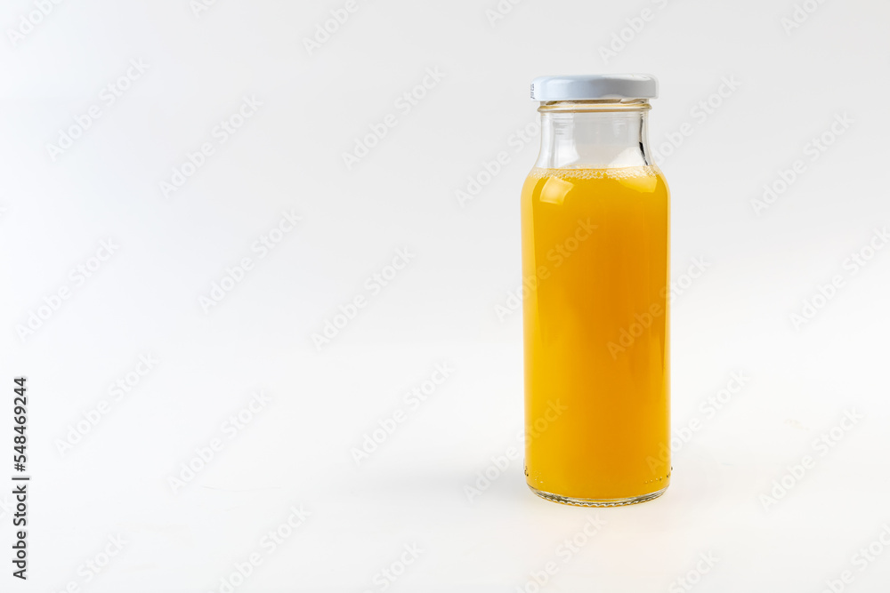 Closed glass bottle with fruit juice on a white background. space for text, copyspace Closed glass bottle with fruit juice on a white background. space for text, copyspace