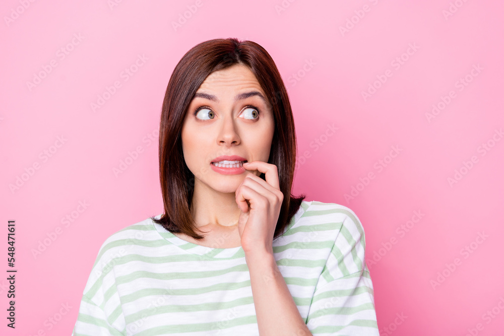 Photo portrait of pretty young woman look anxious empty space have problems wear trendy striped clothes isolated on pink color background Photo portrait of pretty young woman look anxious empty space have problems wear trendy striped clothes isolated on pink color background