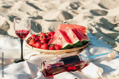 Champagne with a tray of fruits, strawberries and cherries on a picnic.