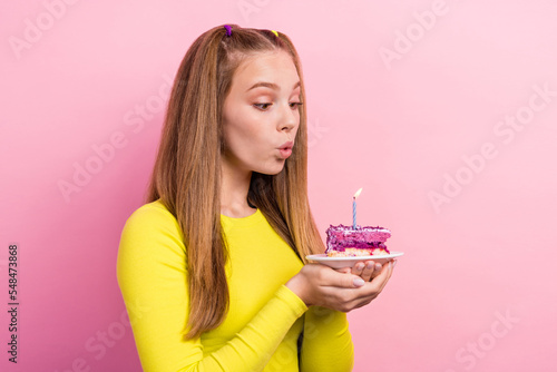 Photo of shiny dreamy schoolgirl wear yellow top holding cake piece plate having birthday wish isolated pink color background