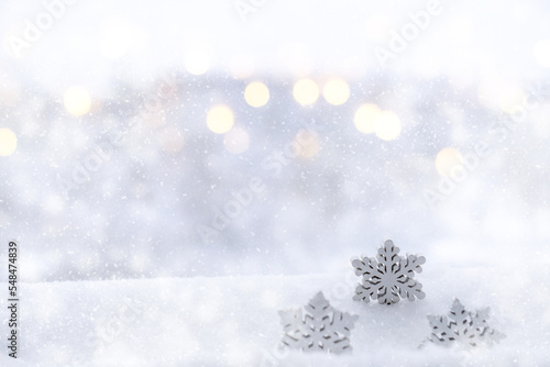 Snowflakes on a blurred background of abstract glitter lights, silver and gold, de-focused. New Year, Christmas holiday background